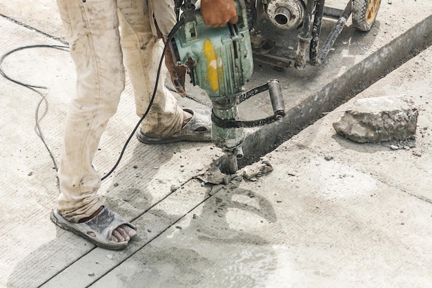 Premium Photo | Construction worker using jackhammer drilling concrete ...