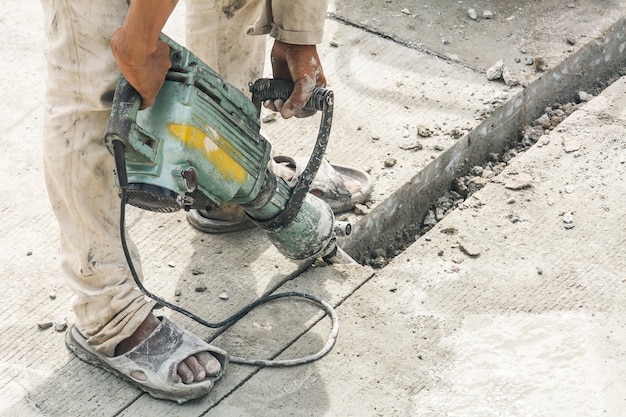 Premium Photo | Construction worker using jackhammer drilling concrete ...