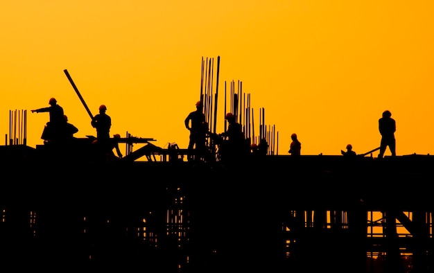 Construction workers at sunset. Free Photo