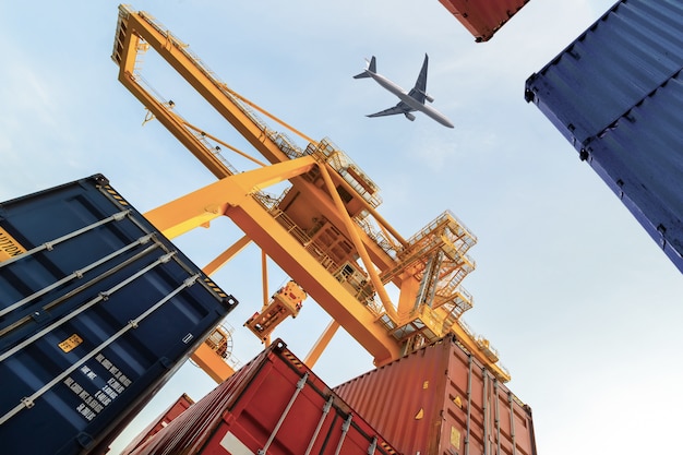 Container cargo freight ship with working crane loading bridge in shipyard for logistic Premium Photo