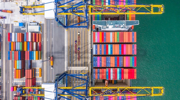 Container ship loading and unloading in deep sea port, aerial top view of business logistic import and export Premium Photo