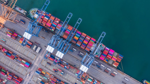 Container ship loading and unloading in deep sea port Premium Photo