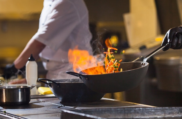 Cook making dinner in the kitchen of high-end restaurant. Premium Photo
