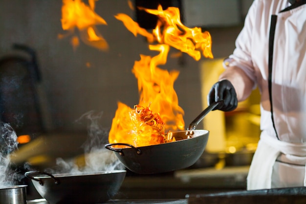 Premium Photo | Cook making dinner in the kitchen of high-end restaurant.