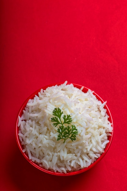 Premium Photo | Cooked plain white basmati rice in a red bowl on red ...