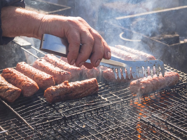 Premium Photo | Cooking bbq meat. romanian mititei and ...