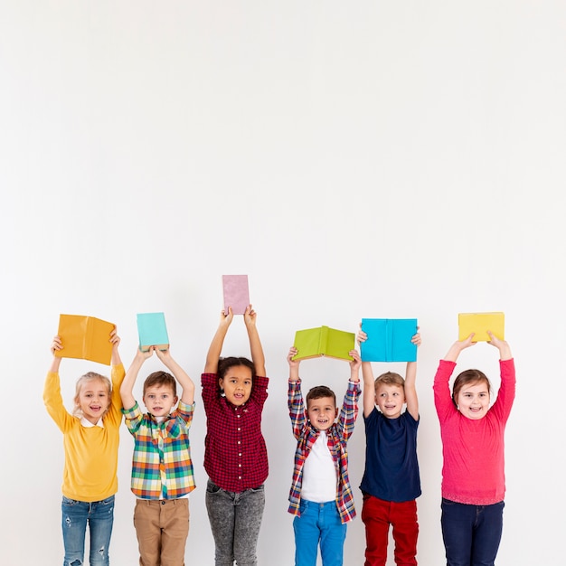 Copy-space childrens holding books above heads Free Photo