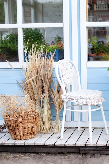 Premium Photo Corner Of Garden In Fall Romantic Porch Patio Chair And Basket With Spikelets Near Wooden Blue House In Countryside Terrace In Rustic Style Old Coffee Terrace Street Cafe Modern