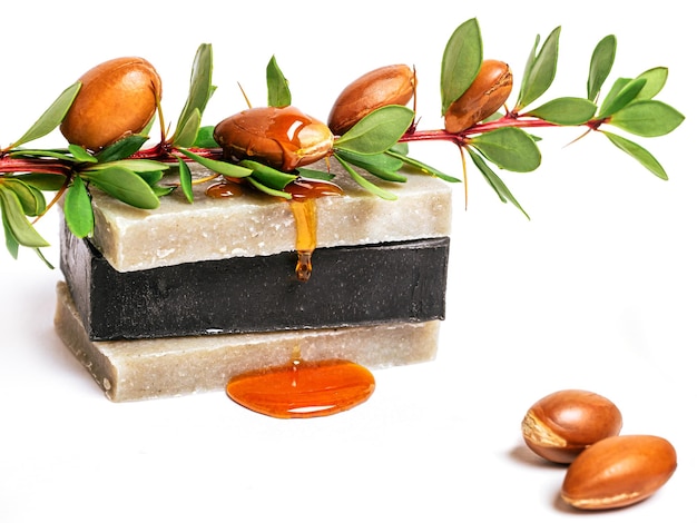  Cosmetic means cosmetic oil argan nuts and handmade soap on isolated background Premium Photo
