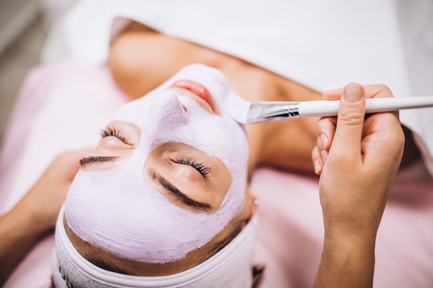 Cosmetologist applying mask on a face of client in a beauty salon Free Photo