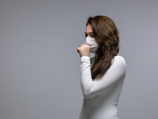 Free Photo | Coughing girl covering her mouth in white protective mask