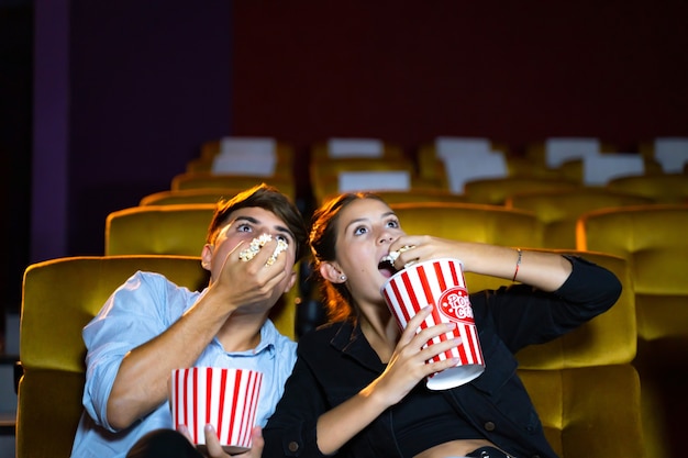 Premium Photo | Couple eating popcorn at movie theater seats