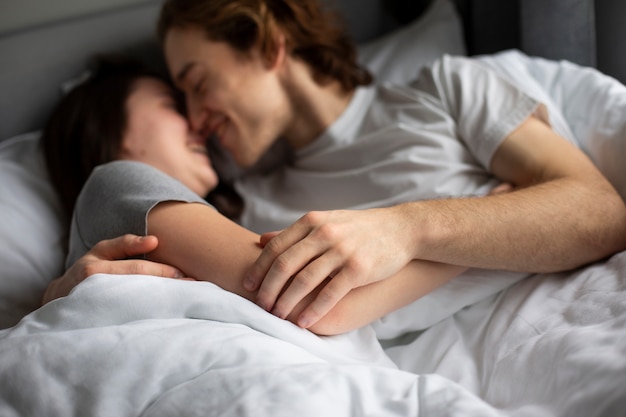 ベッドで愛情を込めて抱きしめるカップル 無料の写真