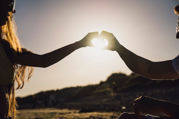 Couple forming heart with hands | Free Photo