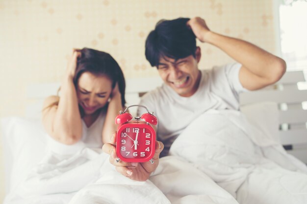 Couple Having Trouble With Getting Up Early In The Morning On The Bed