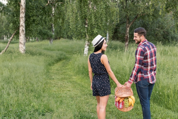 Free Photo | Couple having a walk holding a picnic basket