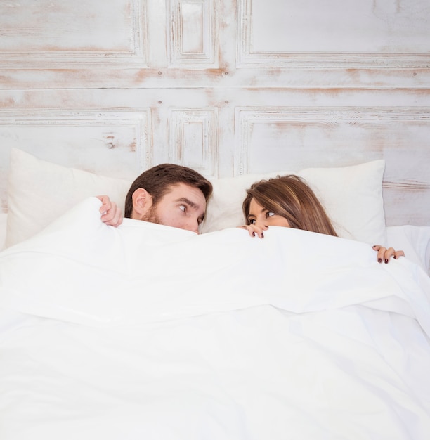 Free Photo Couple Hiding Under Blanket On Bed