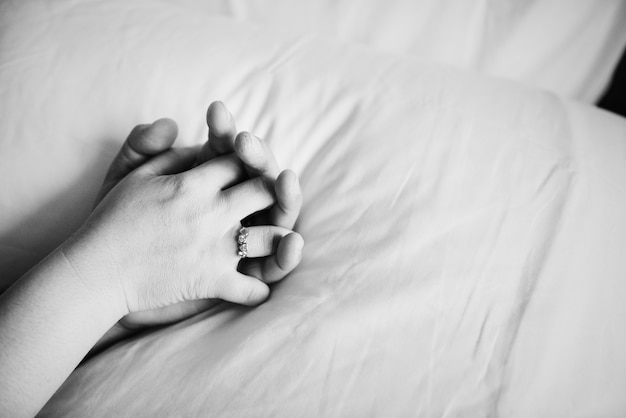 Couple holding hands on the bed Free Photo