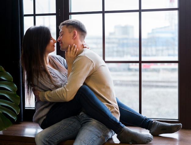 Free Photo Couple Kissing Embraced In Front Of Window