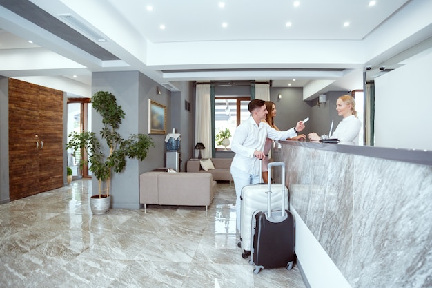 Couple near reception desk in hotel Premium Photo