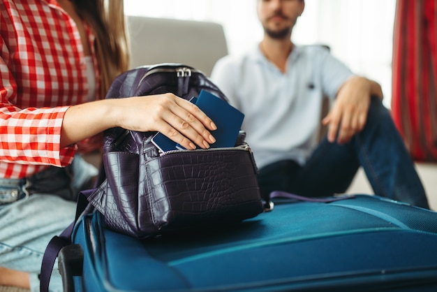 Premium Photo | Couple packing their suitcases and take documents