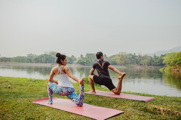 Free Photo | Couple practisisng yoga beside the lake