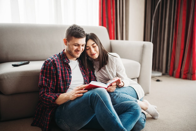 Premium Photo | Couple sitting on floor and looks at book together