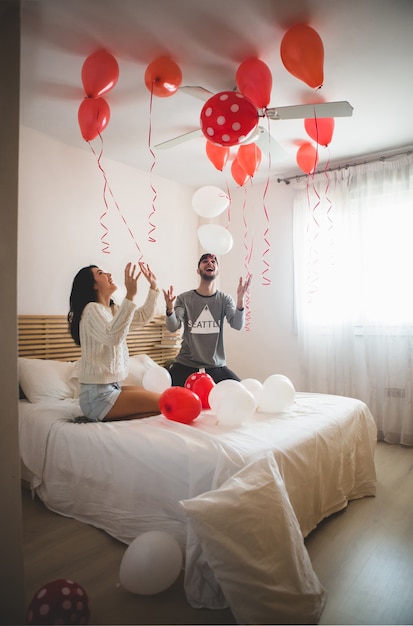 Couple Smiling With Hands Raised Looking At The Ceiling Full