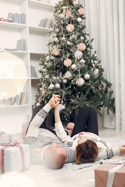 カップルはクリスマスの飾りと家で時間を過ごします 無料の写真