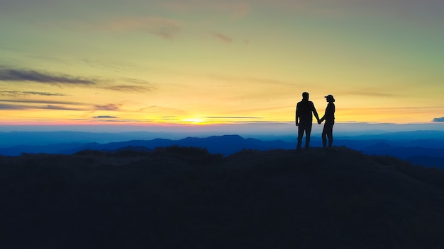 Premium Photo | The couple standing on the mountain on the sunrise ...
