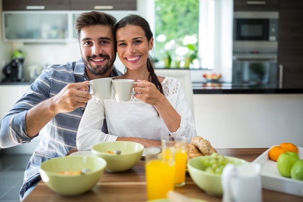 Premium Photo | Couple toasting a cup of coffee while having breakfast