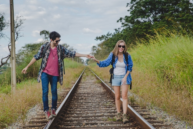 Couple Walking On Train Tracks And Holding Hands Photo