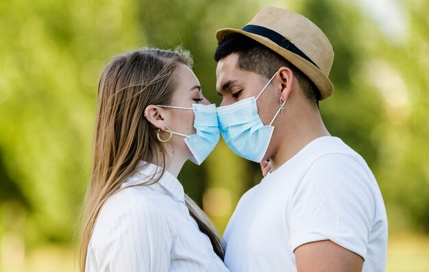 公園でキスするマスクとカップル プレミアム写真