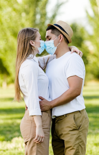 公園でキスするマスクとカップル プレミアム写真