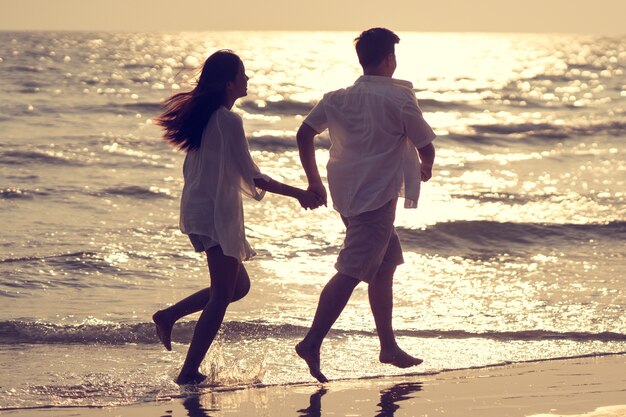 Couples holding hands beach romp happily Photo | Premium Download