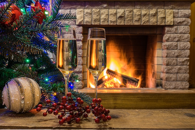 Cozy fireplace. champagne wine before christmas tree decorated ...