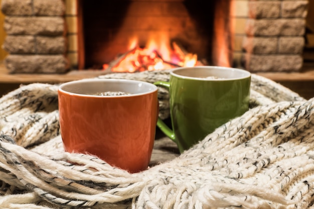 Cozy Scene Near Fireplace With Cups Of Hot Tea And Cozy Warm Scarf