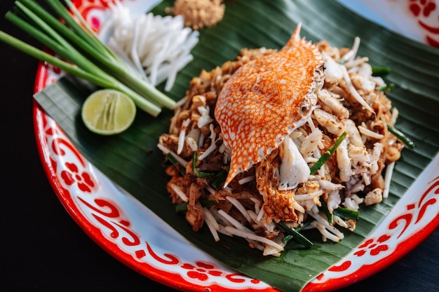 Premium Photo | Crab pad thai served with lime, scallions, bean sprouts