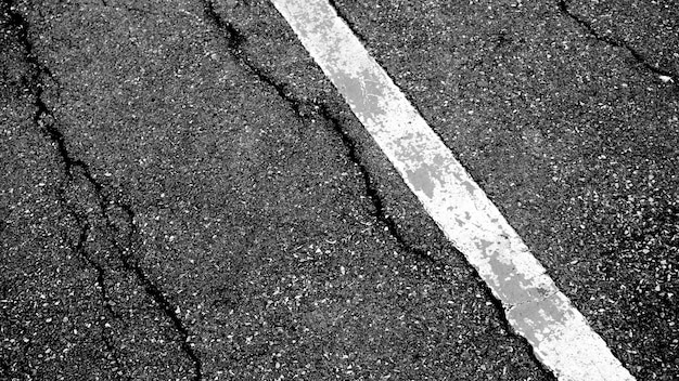 亀裂と白い破線トップビューの背景を持つアスファルト道路のテクスチャ プレミアム写真