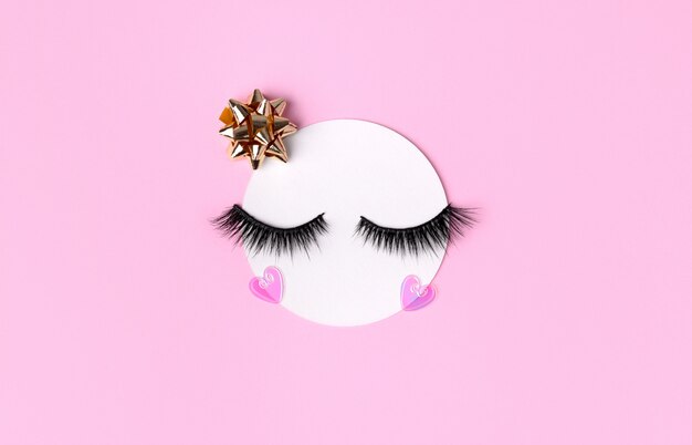 Creative layout with eyelashes. closed eyes on pastel pink background Premium Photo