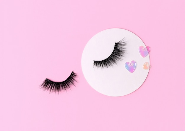 Creative layout with eyelashes. closed eyes on pastel pink background Premium Photo