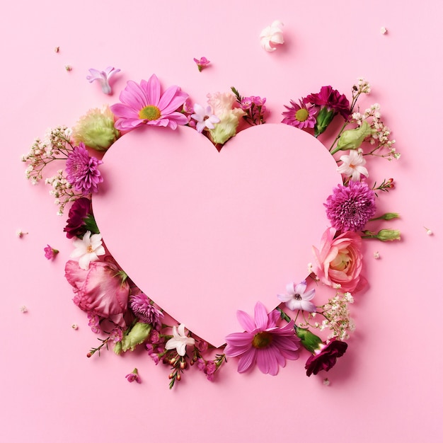 ピンクの花 パンチの効いたパステル調の背景の上の紙のハートのクリエイティブレイアウト バレンタインの日カード パンチの効いたパステル紙の背景に刈り取ら心 プレミアム写真