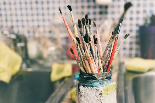 Premium Photo | Creative workshop of the artist. paint brushes in a jar.  many brushes for painting in one place