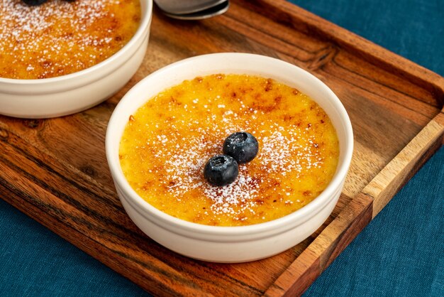 Premium Photo | Creme brulee in ramekin on wooden tray