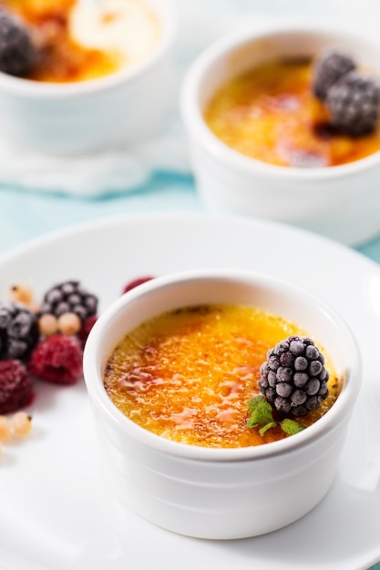 Premium Photo | Creme brulee with berry on a white table