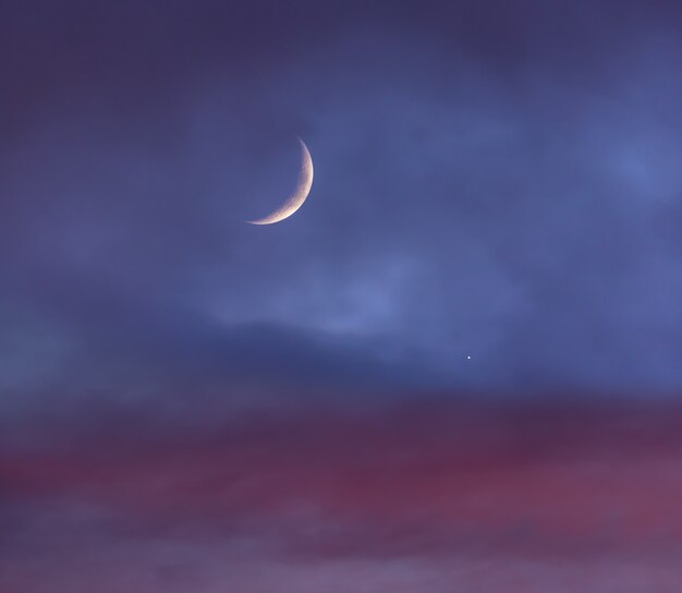 金星の横にある夕暮れ時の曇り空の上の三日月 プレミアム写真