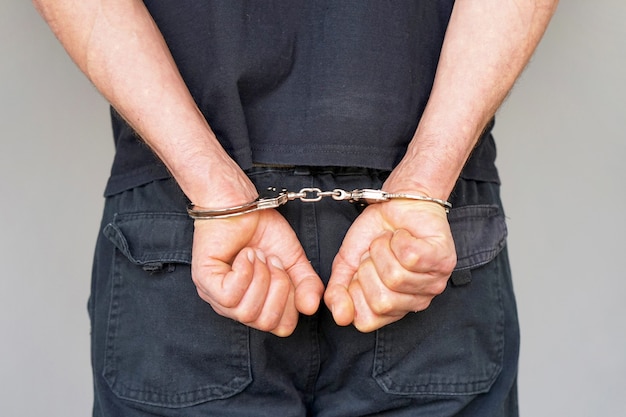 Premium Photo | Criminal hands locked in handcuffs. close-up view