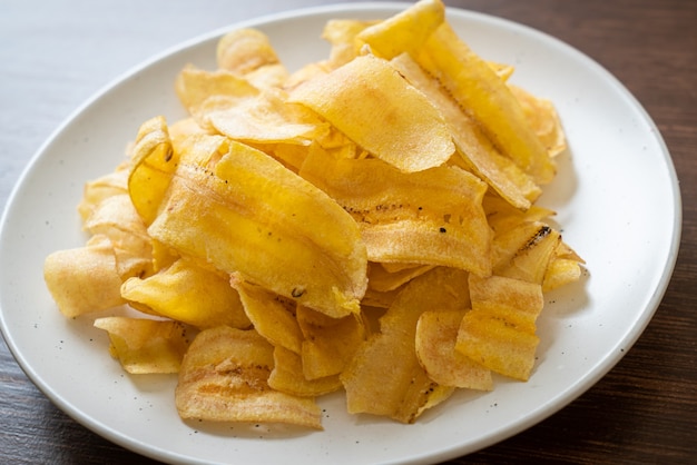 Premium Photo | Crispy banana chips - fried or baked sliced banana