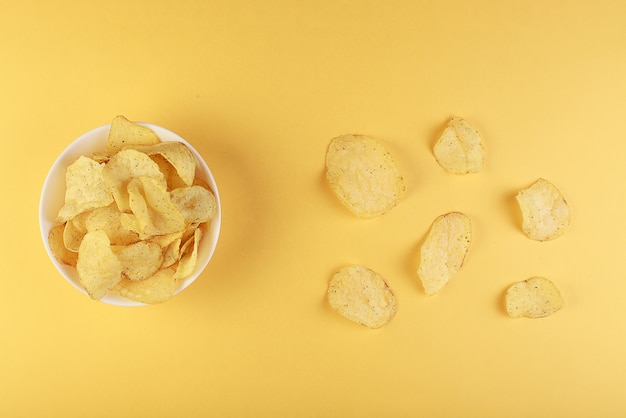 Premium Photo Crispy Potato Chips In Bowl On Yellow Background Top View