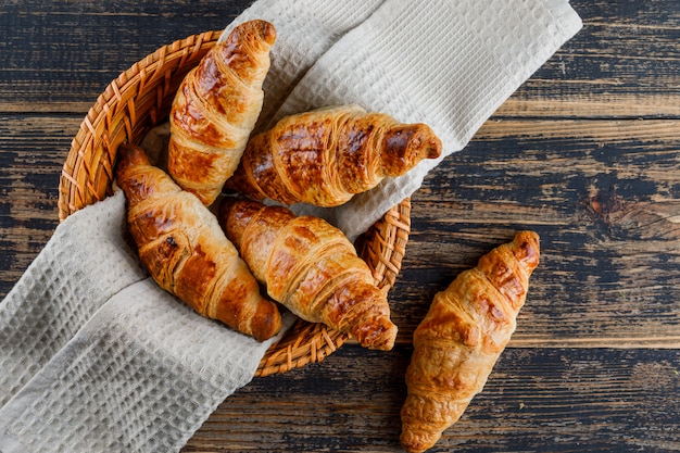 Free Photo | Croissant in a basket with cloth on a wooden table. flat lay.